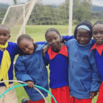 Girls smiling outside by soccer net