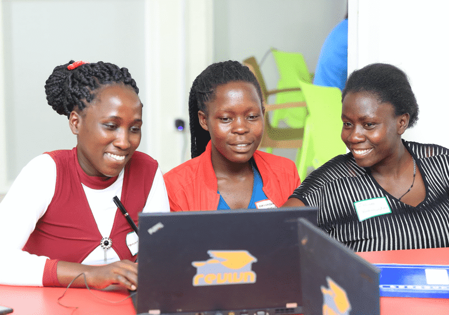 Three women smiling at laptop screen