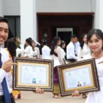 Two students pose at graduation. PEPY Empowering Youth offers training in literacy and technology skills in Cambodia.