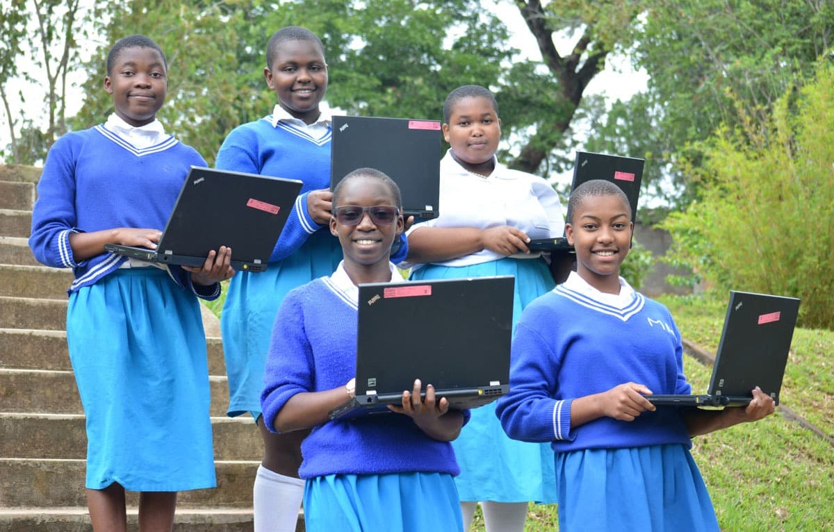 Students pose with computers. The Centre for Youth and Development impacts STEM education in Malawi.