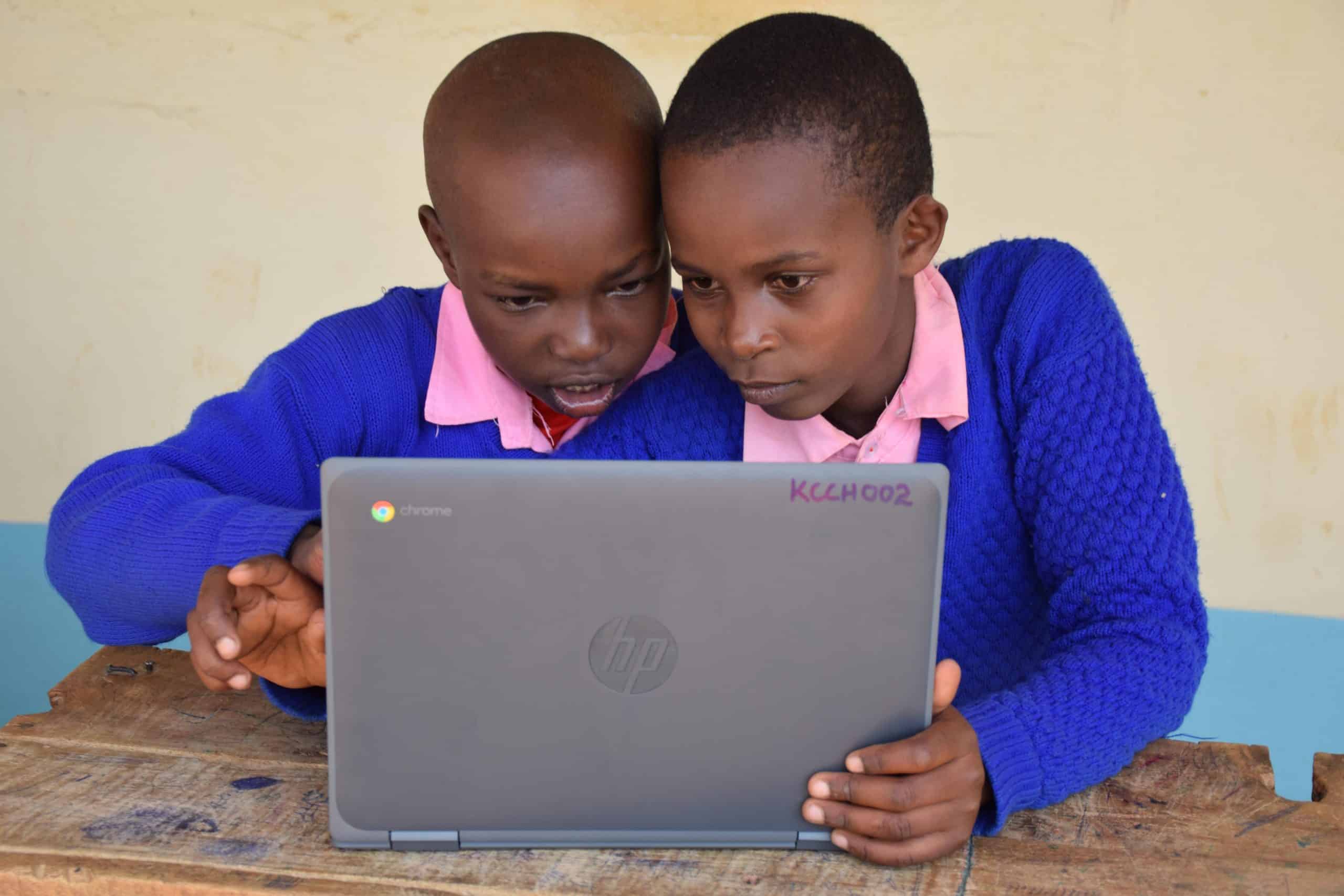 Two students use a laptop. Kenya Connect enhances resources for rural schools through technology labs in Kenya.