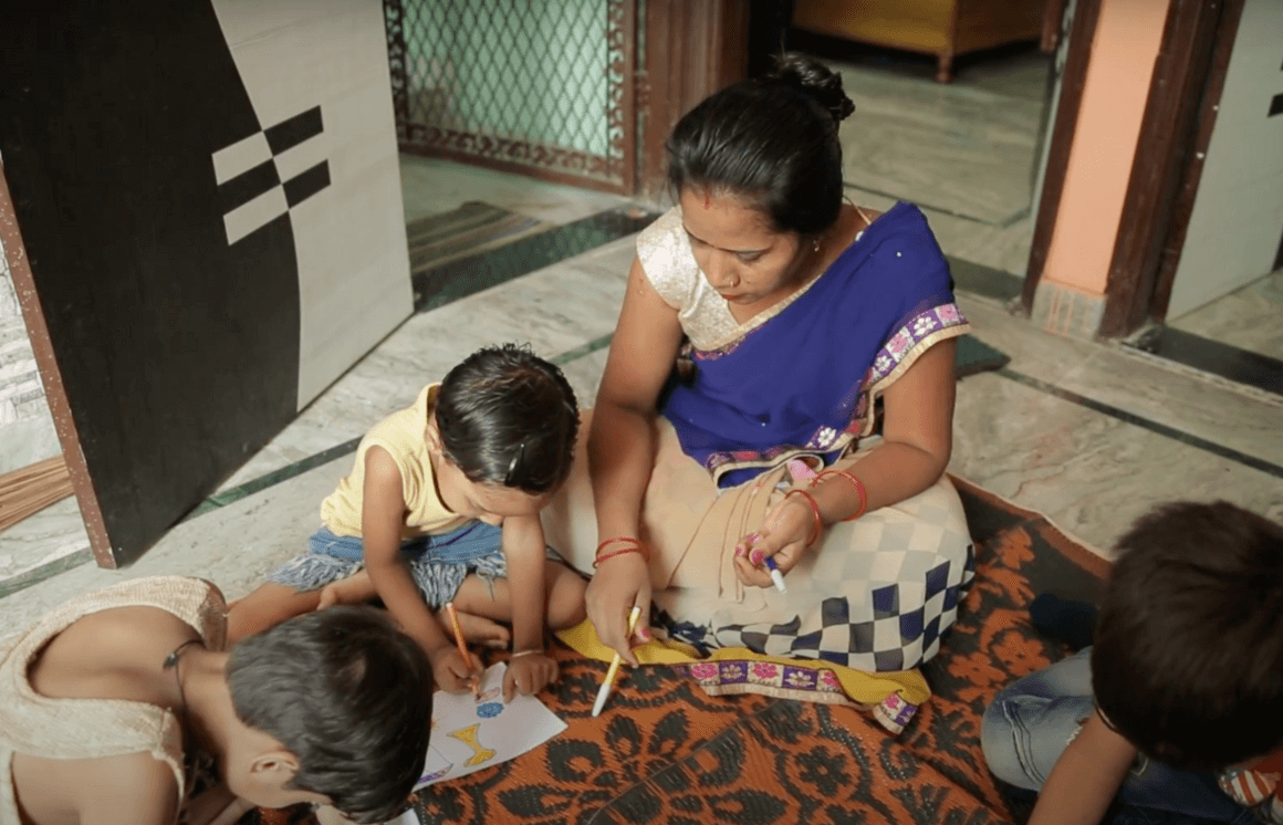 Mother and child perform activity to stimulate early childhood development with Dost Education.
