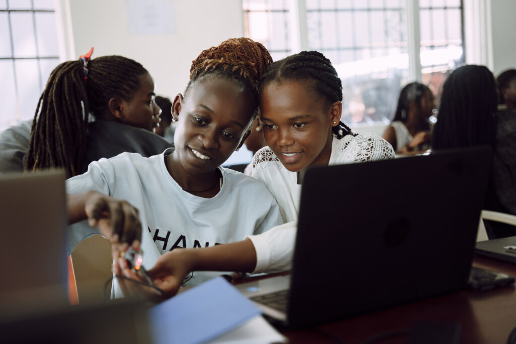 Ugandan Women working on laptops as part of Team4Tech skilled volunteering project