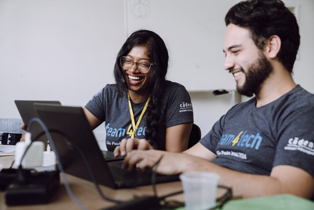 Team4Tech Skills-Based Volunteering | Volunteers collaborating in front of a laptop during an on-site project in Brazil